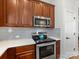 A well lit kitchen featuring gray backsplash, stainless steel appliances and wood-look flooring at 4148 Cedar Point Ave, Matthews, NC 28104