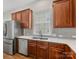 A well lit kitchen featuring gray backsplash, stainless steel appliances and wood-look flooring at 4148 Cedar Point Ave, Matthews, NC 28104