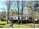 Lakeside home with expansive deck and steps leading down to the yard. Surrounded by mature trees at 141 Sunrise Pt, New London, NC 28127