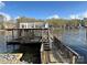 Picturesque dock featuring covered boat slip, stairs, and scenic lake views at 141 Sunrise Pt, New London, NC 28127