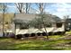 Quaint, light-colored house with lake access and shutters, complemented by a blossoming tree at 141 Sunrise Pt, New London, NC 28127