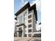 Modern condo building featuring a striking exterior, large windows, and private balconies, all under a contemporary roof design at 19329 Watermark Dr # 142, Cornelius, NC 28031