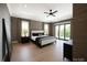 Expansive main bedroom featuring a tray ceiling, hardwood floors, balcony, and modern ceiling fan at 19329 Watermark Dr # 142, Cornelius, NC 28031