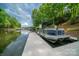 Modern boat dock featuring a large pontoon boat with lake access and scenic views of the surrounding nature at 4273 Stormy Pointe Ct, Denver, NC 28037