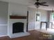 Spacious living room with a painted brick fireplace and hardwood flooring at 443 Silversmith Ln # 16, Charlotte, NC 28270