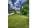 Large backyard featuring a spacious lawn, white fencing, and a charming two-story home in the background at 443 Silversmith Ln, Charlotte, NC 28270