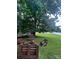 Backyard featuring a fire pit with seating, a storage shed, mature trees, and a well-maintained lawn at 443 Silversmith Ln, Charlotte, NC 28270
