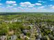 An aerial view captures a residential neighborhood nestled amidst green trees under a blue sky filled with white clouds at 7605 Berryfield Ct, Waxhaw, NC 28173