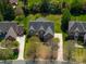 Aerial view showcasing a spacious home, mature trees, a long driveway, and lush green lawn in a serene neighborhood setting at 7605 Berryfield Ct, Waxhaw, NC 28173