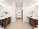 Large bathroom features dual sinks with dark wood cabinets, tile floors, and plenty of natural light at 7605 Berryfield Ct, Waxhaw, NC 28173