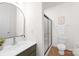 Bright bathroom featuring a shower, toilet, sink with a gray cabinet, and a neutral color scheme at 7605 Berryfield Ct, Waxhaw, NC 28173