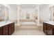 Luxury bathroom suite showcasing a soaking tub with pillars and a double sink vanity with dark wood cabinets at 7605 Berryfield Ct, Waxhaw, NC 28173