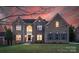 Striking brick home featuring a manicured lawn, symmetrical windows with shutters, and a grand arched window above the front door at 7605 Berryfield Ct, Waxhaw, NC 28173