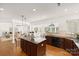 Bright kitchen with island, dark cabinets, and open layout to dining and living areas at 7605 Berryfield Ct, Waxhaw, NC 28173