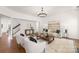 Bright living room with modern chandelier, plush rug, and neutral-toned furniture at 7605 Berryfield Ct, Waxhaw, NC 28173