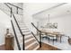 Elegant staircase with hardwood steps and black railings leads to the upper level with dining room view at 7605 Berryfield Ct, Waxhaw, NC 28173