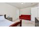 Neutral bedroom with a red couch, large bed, and side tables at 7925 Woodmere Dr, Harrisburg, NC 28075