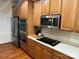 Kitchen with stainless steel microwave, cooktop, and wooden cabinets at 7925 Woodmere Dr, Harrisburg, NC 28075