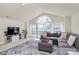 Bright living room featuring large window, vaulted ceiling, gray sofa and modern decor at 7925 Woodmere Dr, Harrisburg, NC 28075