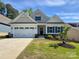 Charming one-story home with a white exterior, dark shutters, a two-car garage, and a well-manicured lawn at 10241 Black Locust Ln, Charlotte, NC 28215