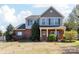 Charming two-story home featuring brick and siding, a welcoming front porch, and manicured landscaping at 4519 S Potter Rd, Monroe, NC 28112