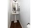 Cozy powder room showcasing a pedestal sink and wood-look flooring at 4519 S Potter Rd, Monroe, NC 28112