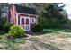 Small red shed with white trim in a grassy backyard surrounded by trees at 4519 S Potter Rd, Monroe, NC 28112