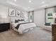 Spacious main bedroom with a tray ceiling, large bed, and elegant decor, creating a relaxing retreat at 1018 Mapletree Ln, Indian Trail, NC 28079
