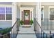Inviting front entrance featuring a red door with glass, decorative wreath, and black metal railing at 1034 Currituck Way, York, SC 29745