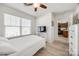 Bedroom featuring a ceiling fan, a window and a TV with a glimpse of the kitchen area at 104 S Canyon Rdg, Mount Holly, NC 28120