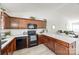 A modern kitchen area featuring white counter tops, wooden cabinets and sleek, black appliances at 104 S Canyon Rdg, Mount Holly, NC 28120