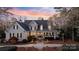 Stunning two-story home with lush landscaping, fountain, and a welcoming front porch at sunset at 111 Moors End Loop, Mooresville, NC 28117