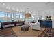 Open-concept living room with water views, comfortable seating, and wet bar access at 111 Moors End Loop, Mooresville, NC 28117