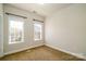 Empty bedroom with two windows, carpet, and neutral-colored walls at 1122 Dean Hall Ln, Matthews, NC 28105