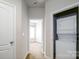 Hallway with a stacked washer and dryer, leading to a bright bedroom at 1122 Dean Hall Ln, Matthews, NC 28105