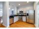 Modern kitchen featuring stainless steel appliances, ample counter space, and hardwood flooring at 1122 Dean Hall Ln, Matthews, NC 28105