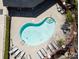 Aerial view of kidney-shaped pool, showing tanning deck with lounge chairs and tables near the brick perimeter at 1122 Dean Hall Ln, Matthews, NC 28105