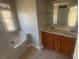 Bathroom with a double sink vanity and a tub under a window at 1134 Riverside Dr, Charlotte, NC 28214