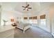 Bright bedroom featuring a tray ceiling, plush carpet, and large windows at 115 Stonewall Beach Ln, Mooresville, NC 28117