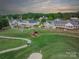 Aerial view showcasing a lush golf course with a beautiful clubhouse and cart at 115 Stonewall Beach Ln, Mooresville, NC 28117