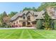 Stunning home with manicured lawn, mature trees, and charming architectural details at 115 Stonewall Beach Ln, Mooresville, NC 28117