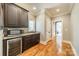 Hallway space showcasing wood floors, dark cabinets, stainless appliances, and a beverage fridge at 115 Stonewall Beach Ln, Mooresville, NC 28117