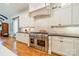 A kitchen featuring a stainless steel stove, white cabinets, and marble backsplash at 115 Stonewall Beach Ln, Mooresville, NC 28117
