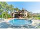 Gorgeous pool area with stone patio and comfortable lounge chairs surrounded by mature trees at 115 Stonewall Beach Ln, Mooresville, NC 28117