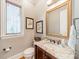 A classic powder room offers a wood vanity, granite countertop, and decorative mirror at 115 Stonewall Beach Ln, Mooresville, NC 28117