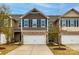 Charming townhome with a two-car garage, stone accents, and blue shutters at 1211 Croft Dr, Fort Mill, SC 29708