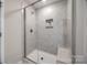 Modern walk-in shower with tiled walls, glass door, and built in shelf at 1211 Croft Dr, Fort Mill, SC 29708