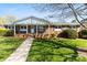 Charming brick home with a welcoming front porch and manicured lawn on a sunny day at 1228 Graystone Dr, Gastonia, NC 28054