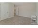 Minimalist bedroom with neutral carpet, white walls, and an adjoining bathroom, offering a blank canvas at 126 Johns Cardinal Dr, Mooresville, NC 28115