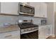 Close-up of kitchen with stainless steel range, granite countertops, and white cabinets at 126 Johns Cardinal Dr, Mooresville, NC 28115